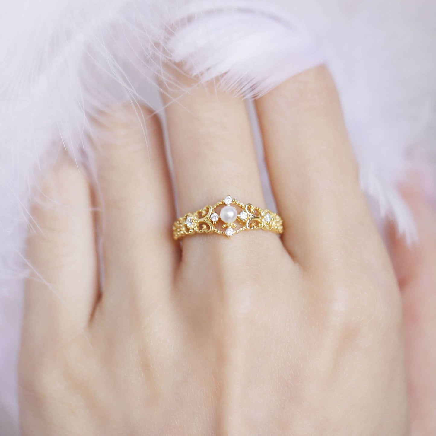 Golden decorative ring featuring a pearl, suitable for women, showcasing a unique design on a hand.