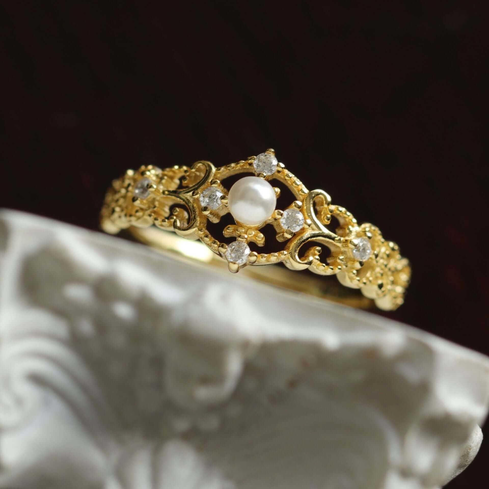 Elegant gold ring with pearl and crystals, featuring intricate floral detailing, perfect for women.